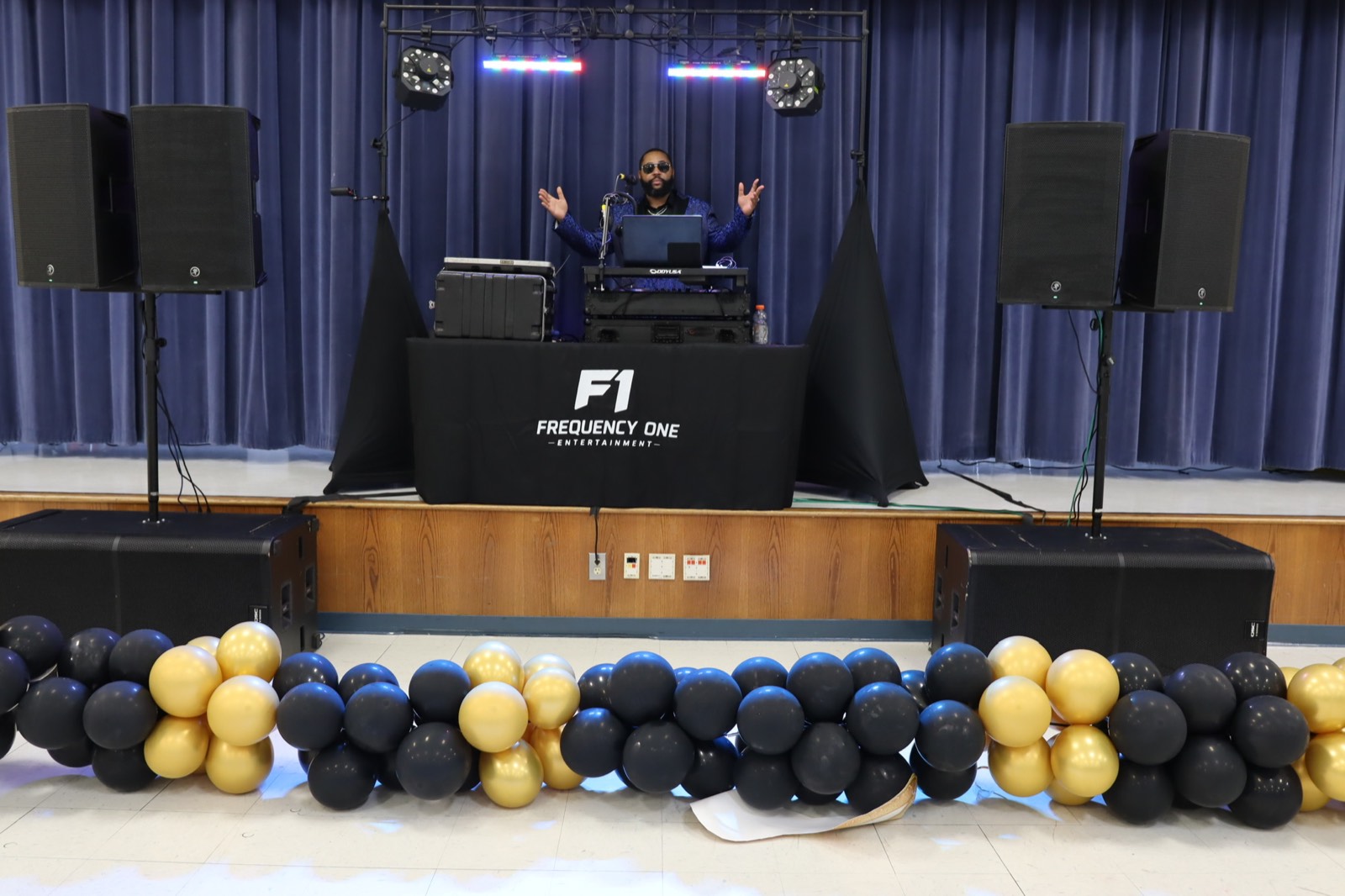 Frequency One full DJ setup with lighting, speakers, and event decor